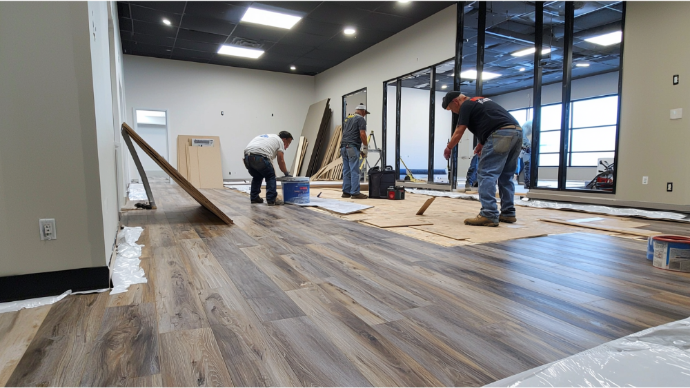 A team installing lvp luxury vinyl plank flooring for a business