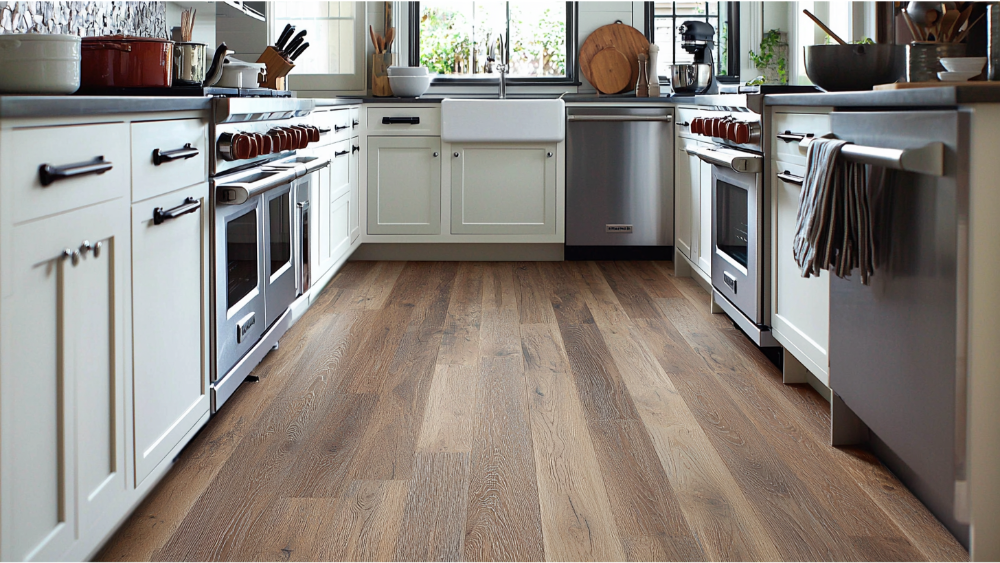 Classic kitchen design with medium brown wood-look vinyl flooring and white shaker cabinets.