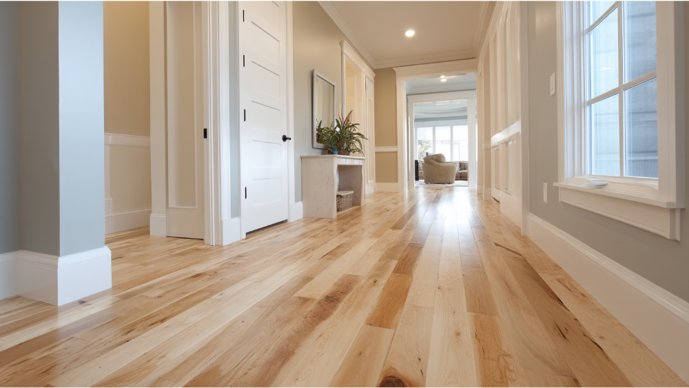 Inviting residential hallway showcasing light maple hardwood floors, white trim, soft wall tones, and a built-in bench with storage.